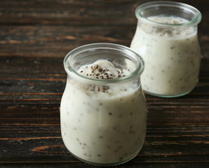 Jars with delicious chia seed pudding on table