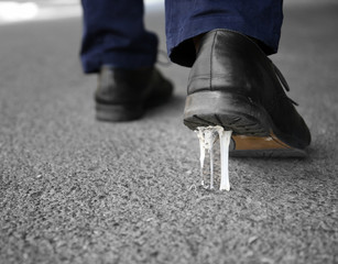 Foot stuck into chewing gum on street. Concept of stickiness
