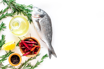 Preparing dorado with spices rosemary, pepper, chili, lemon. White background top view copyspace