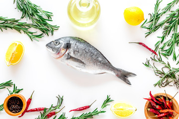 Preparing dorado with spices rosemary, pepper, chili, lemon. White background top view