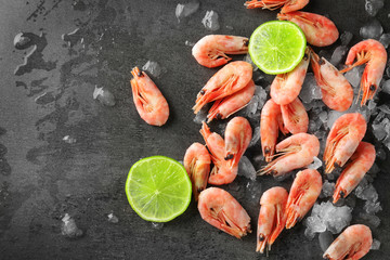 Frozen shrimps with ice on grey background
