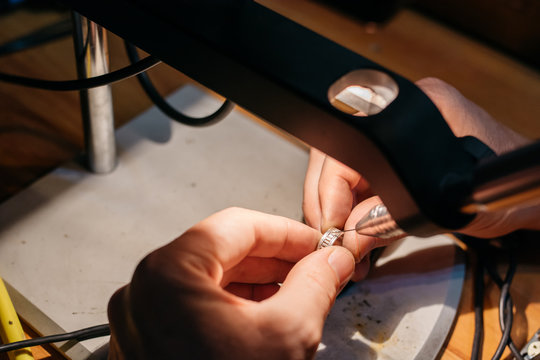 Goldsmith repairing a wedding ring with a welding machine