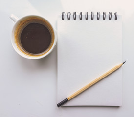 A notebook, a pencil, a Cup of coffee on a white background. Top view 