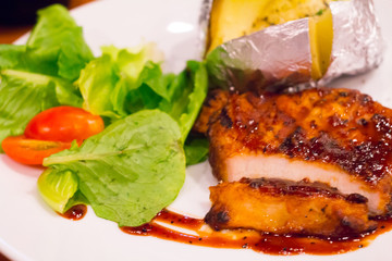 Grilled chicken steak on plate with baked potato and vegetable,Traditional cuisine. Grill kitchen.