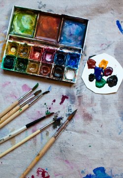 Paint palette, brushes and a canvas