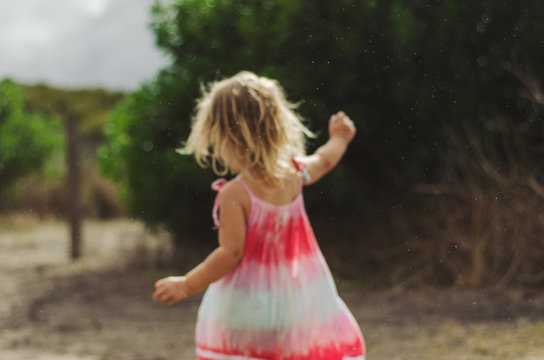 Little girl running free in the rain
