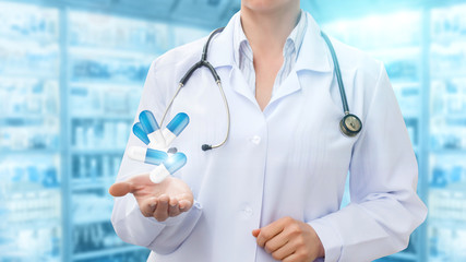 Pharmacist in hand showing pills on the background .