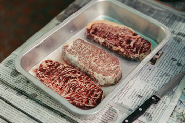 Defrosted raw wagyu beef with marble texture that defrost on stainless steel plate in Bangkok, Thailand.