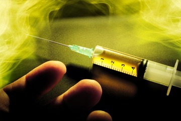 syringe with a drug and a hand