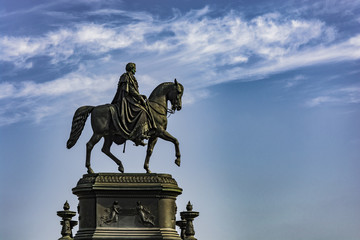 Obraz premium Statue of rider on horse. Monument in Germany under blue sky.