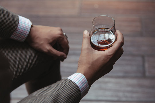 Dapper gentleman holding a glass of rum