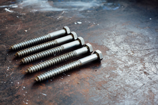 Screw bolts and wrench on worn work table