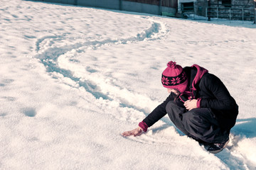 Fototapeta na wymiar young man touching snow while walking in winter