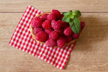 Fresh ripe raspberries in a small basket