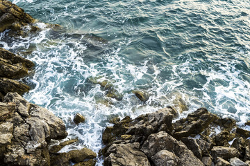 Huge stones in the sea and waves. Evening. View from above. Montenegro. The Budva Riviera