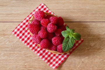 Fresh ripe raspberries in a small basket