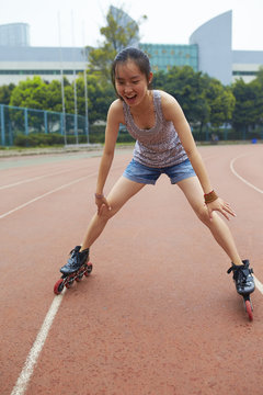 young asian woman learning in-line skate outdoor