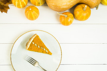 a slice of American pumpkin pie on Thanksgiving Day, decorated with pumpkin seeds. on a white table