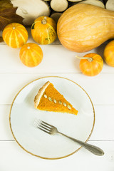 a slice of American pumpkin pie on Thanksgiving Day, decorated with pumpkin seeds. on a white table
