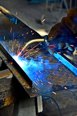 Industrial Worker labourer at the factory welding steel structure