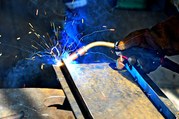 Industrial Worker labourer at the factory welding steel structure