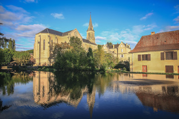 Reflection in water of church in lovely small town La Bugue, Dordogne region, France
