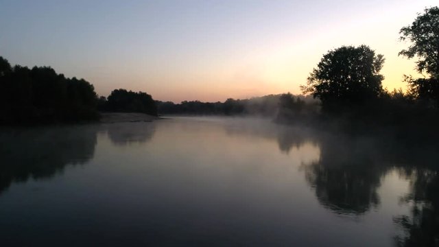 Aerial photography of the river at dawn. Rising mist from the river against the background of the rising sun