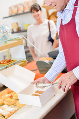 man putting cakes in a box