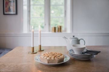 Kaffee und Kuchen wird neben brennenden Kerzen serviert