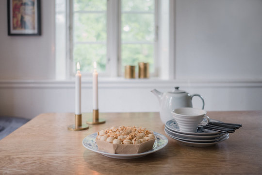 Kaffee und Kuchen wird neben brennenden Kerzen serviert