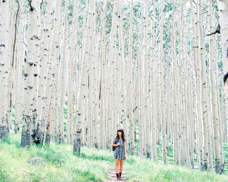 Woman walking in white tree forest