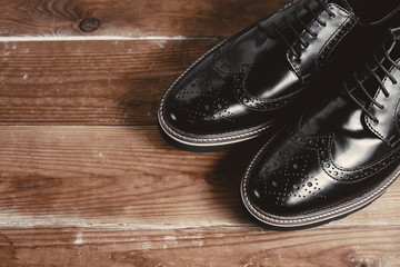 Fototapeta na wymiar Classic black shoes in wooden background