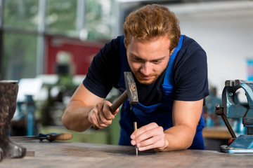 Fitter preparing piece of steel for drilling at a workshop