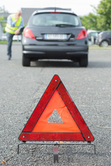 warning triangle behind stalled car