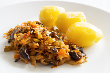cabbage stew with pickled cucumbers and mushrooms garnished with potato