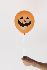 Halloween orange balloon with scary face