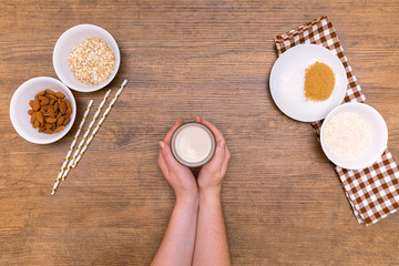 Plant alternative milk recipe: almond, oat, rice in woman hand