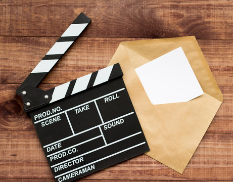 Watching the film. Movie clapperboard and popcorn on blue wooden table background top view copyspace