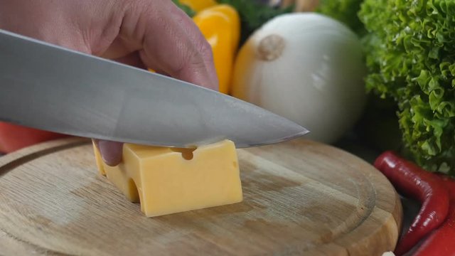 Men's hands cut cheese into pieces