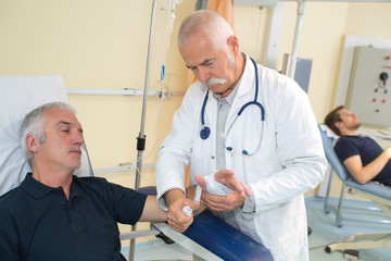 doctor bandaging male patients wrist