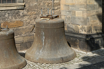 Fototapeta premium Old, dismantled church bells against a background of a stone wall.