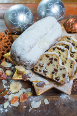 Traditional German Christmas raisins and dried fruits cake with sugar powder and Christmas decorations