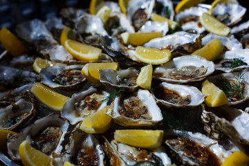 Paella dish with oysters with lemon wedges