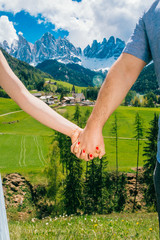 Fototapeta na wymiar Couple holding hands on the mountain background. Dolomite,Italy. Man and woman on vacation in beautiful place.