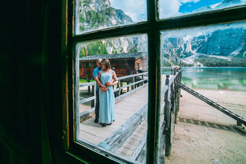 Young couple in love on the pier at lake, lago di braies,Dolomite,Italy. Man and woman on vacation in beautiful place.