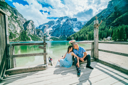 Young couple in love on the pier at lake, lago di braies,Dolomite,Italy. Man and woman on vacation in beautiful place.