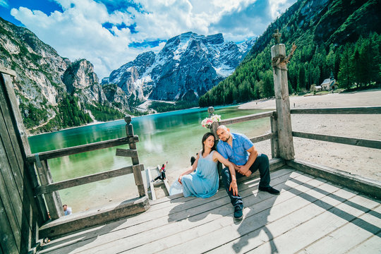 Young couple in love on the pier at lake, lago di braies,Dolomite,Italy. Man and woman on vacation in beautiful place.