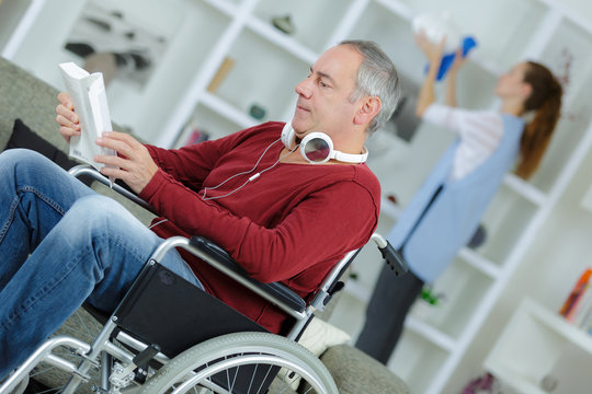 man in wheelchair reading a book