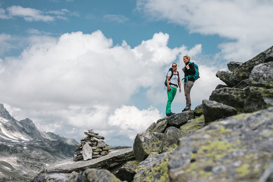 two female hiker standing and overlooking the high alpine scenery