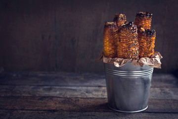 Grilled with corn in metal basket on wooden background with blank space © ltummy